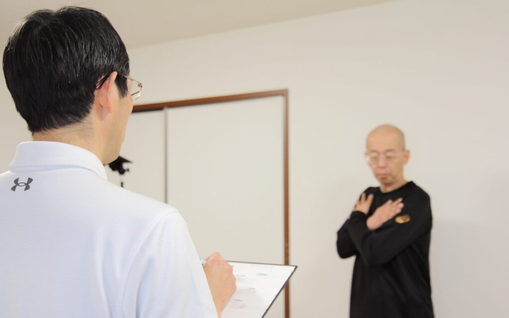 胸郭と胸椎の動きの診察を行う上岡院長